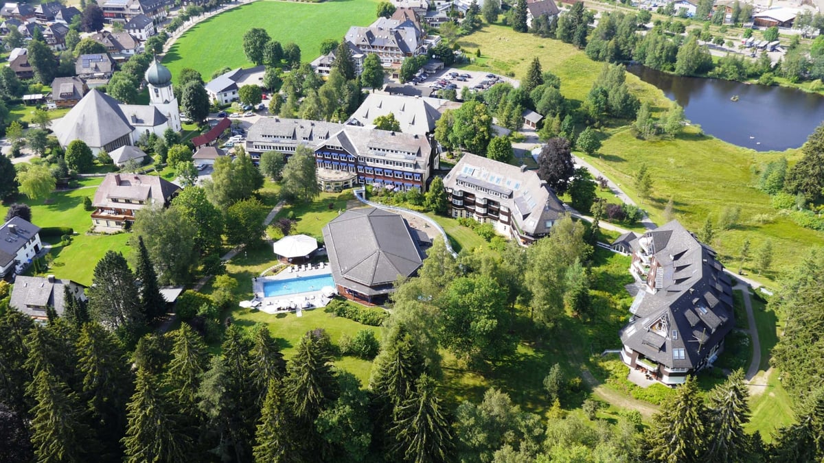 1_Luftaufnahme-der-Kirche-sowie-des-Hotel-Anwesens-in-Hinterzarten-mit-kleinem-See