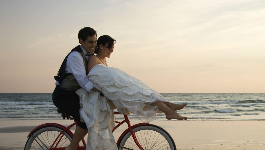 Brautpaar auf Fahrrad am Strand