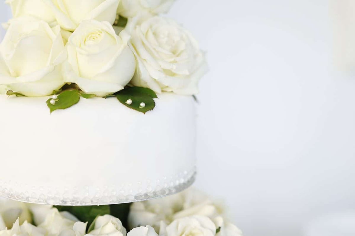 weiße Hochzeitstorte mit weißen Rosen