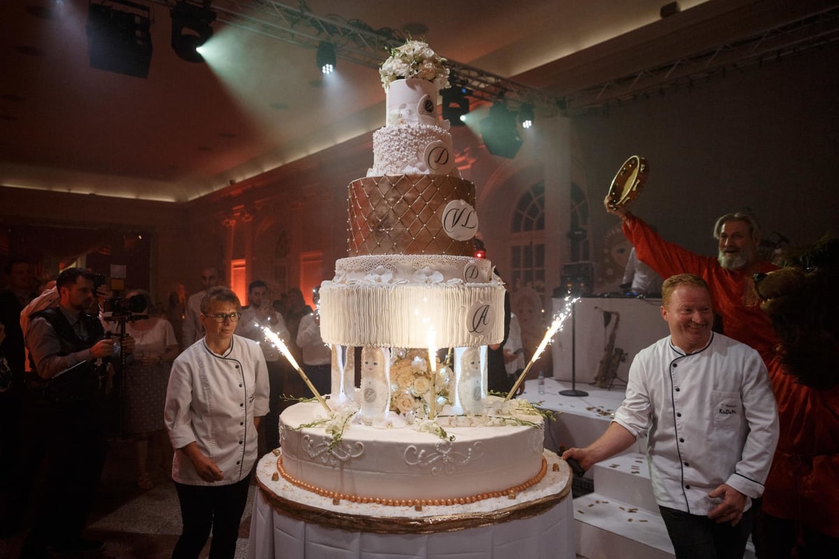Konditoren-mit-Mehrstoeckiger-Hochzeitstorte-mit-Blumen-Tortenfloristik-und-Fontaenen