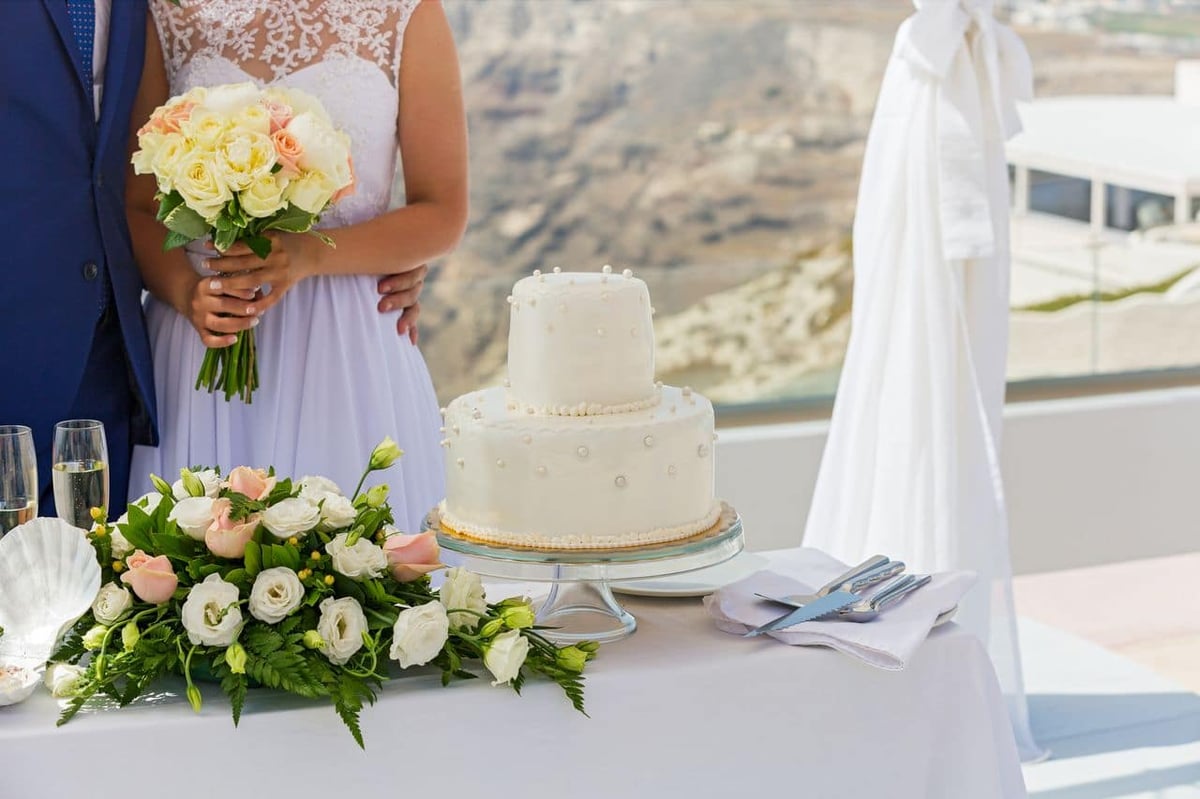 Hochzeitstorte auf dem Tisch und Brautpaar