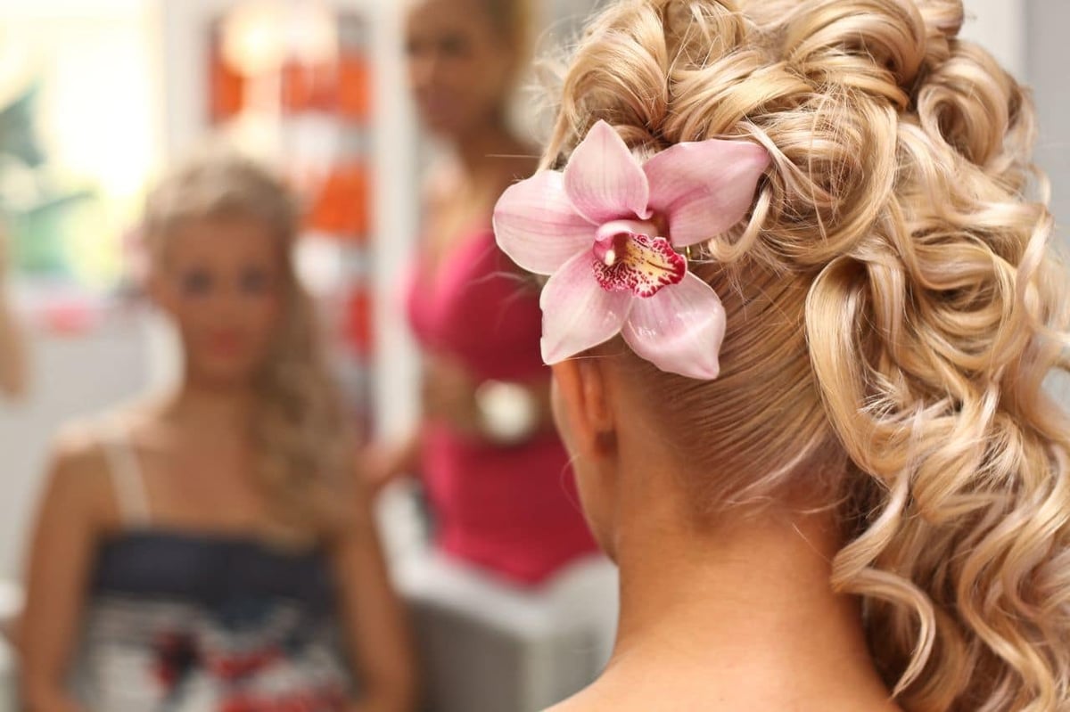 Brautfrisur mit Locken und Blumen