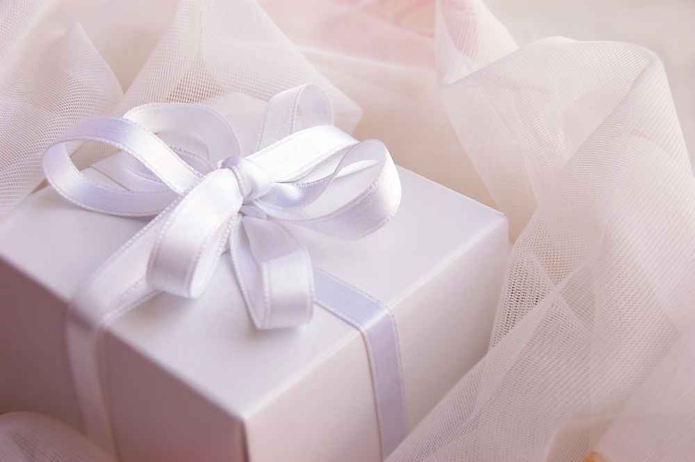weißes Geschenk mit Band auf Tüll